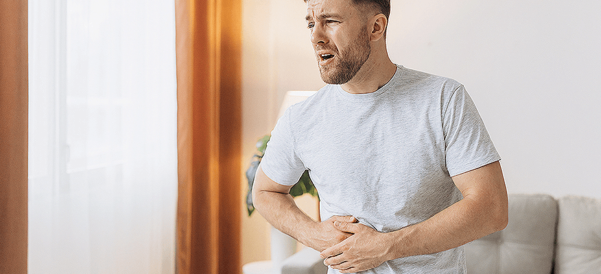 Man holding his abdomen with bloating – tips on how to remove gas from stomach instantly